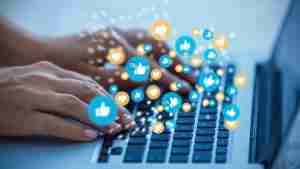 Hands typing on a laptop with engagement icons representing a customer spotlight strategy